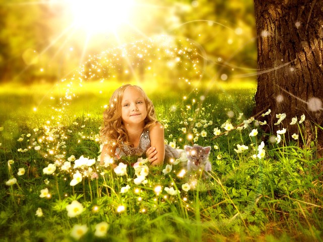 Ребенок-ангелочек с котёночком среди цветов лесной лужайки